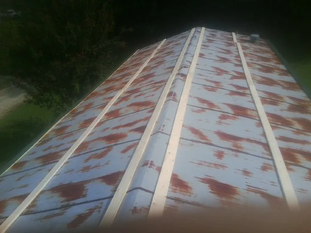 Rusted metal roof panels with new wood purlins before replacement — Storm Damage Roof Repair in Leeds by Roofing Brothers