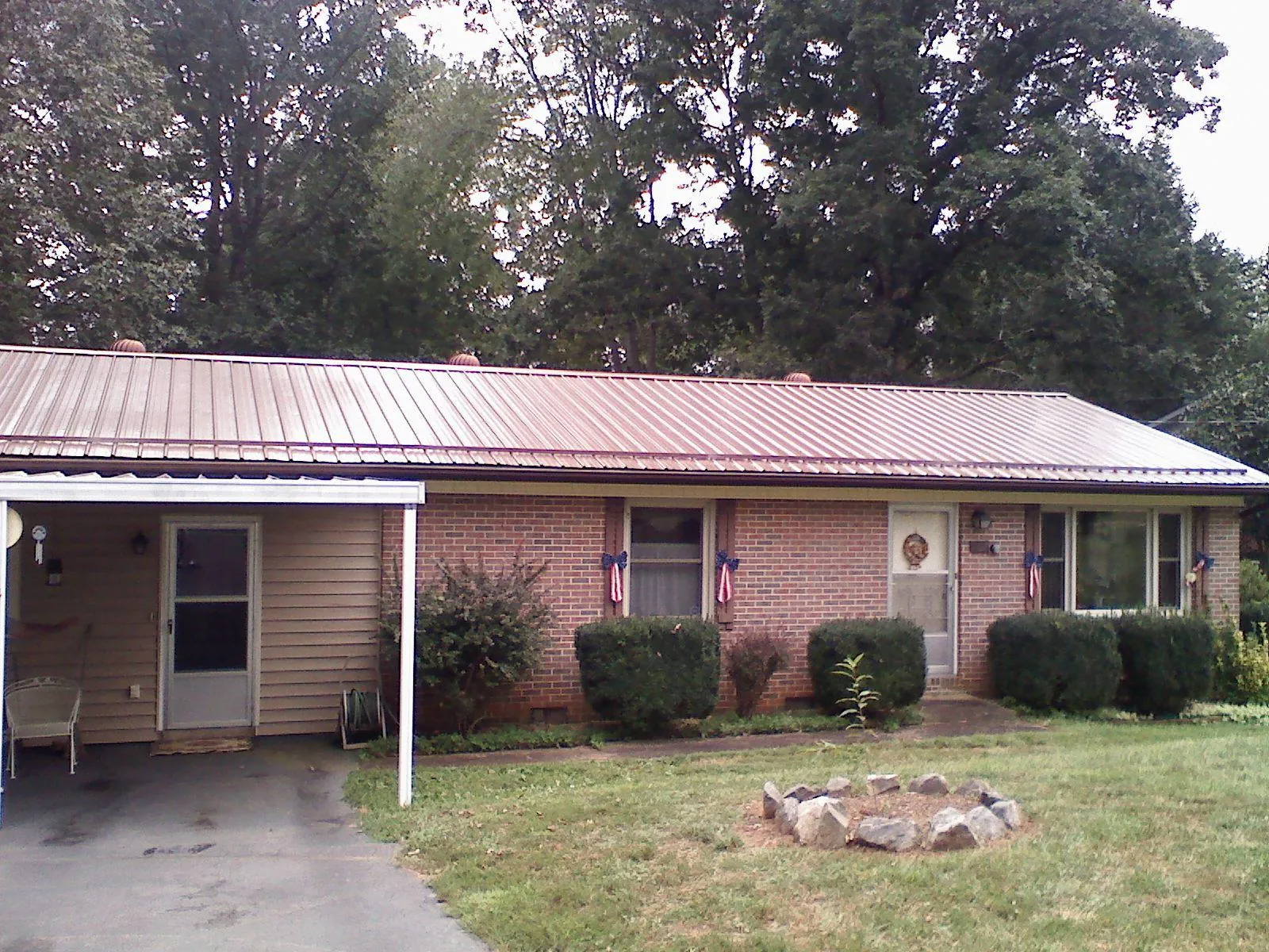 Bronze metal roof and carport on a brick ranch home — Roof Repair work by our crew in Leeds